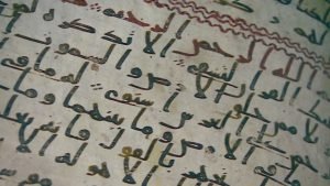 Close-up of part of folio 2 recto, showing chapter division and verse-end markings in Hijazi script